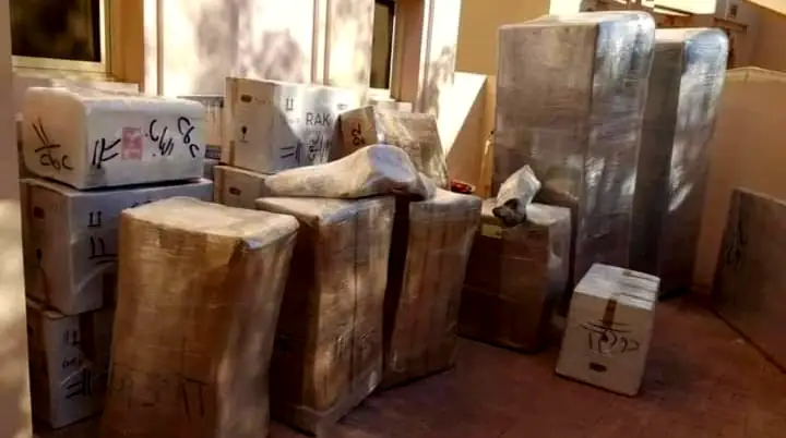 Packed cartons and furniture on a porch