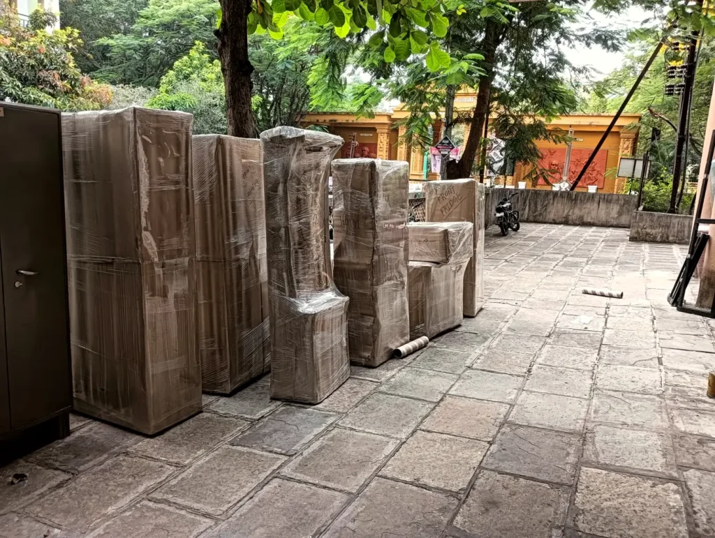 Furniture wrapped in cardboard and stretch film outside a building